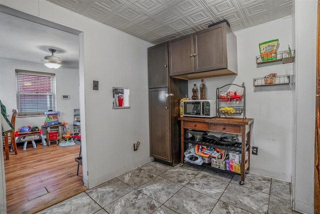 kitchen with ceiling fan, light hardwood / wood-style floors, and dark brown cabinets