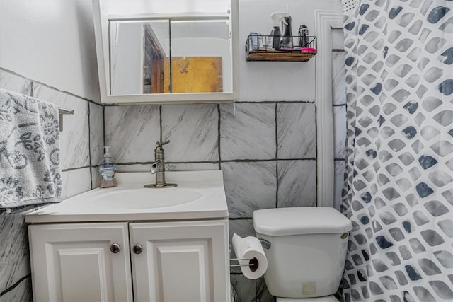 bathroom with toilet, vanity, tile walls, and a shower with curtain