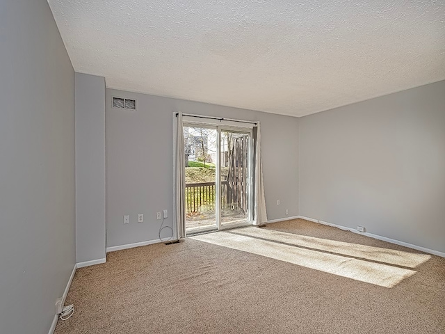 carpeted spare room with a textured ceiling