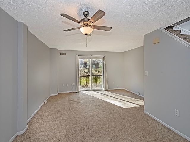 unfurnished room with a textured ceiling, light carpet, and ceiling fan