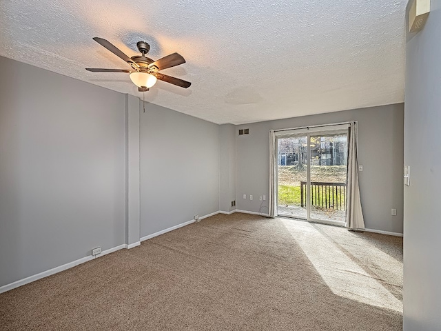 carpeted empty room with ceiling fan and a textured ceiling