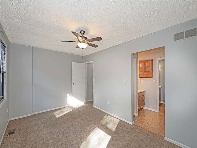 carpeted spare room with a textured ceiling and ceiling fan