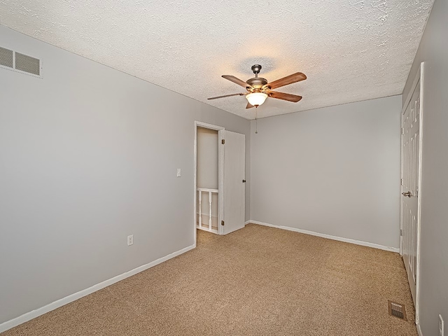 carpeted empty room with a textured ceiling and ceiling fan