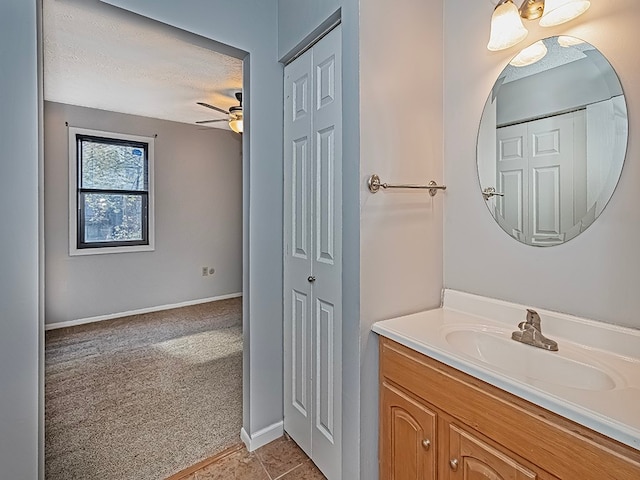 bathroom featuring vanity, ceiling fan, and a textured ceiling