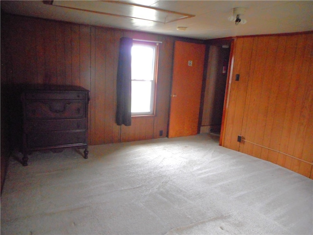 carpeted empty room with wooden walls