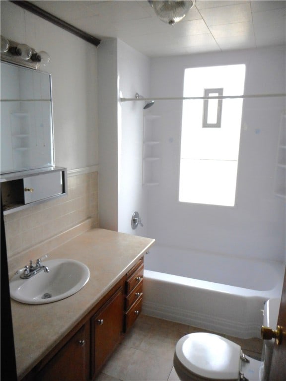 bathroom with vanity, a healthy amount of sunlight, tile patterned floors, and bathtub / shower combination