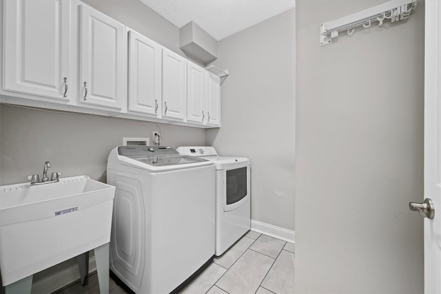 washroom featuring cabinets, light tile patterned flooring, sink, and washer and clothes dryer