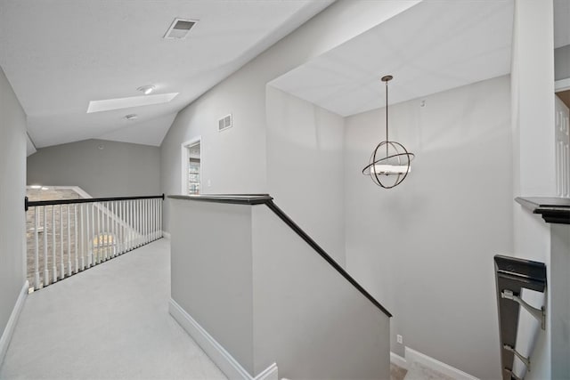 staircase featuring carpet flooring and lofted ceiling with skylight