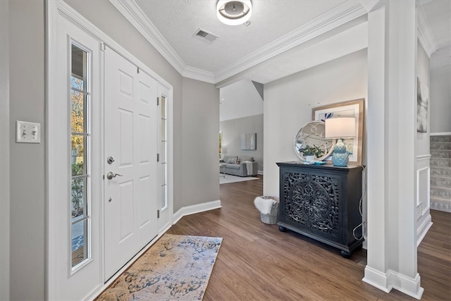 entryway with a textured ceiling, wood-type flooring, and crown molding