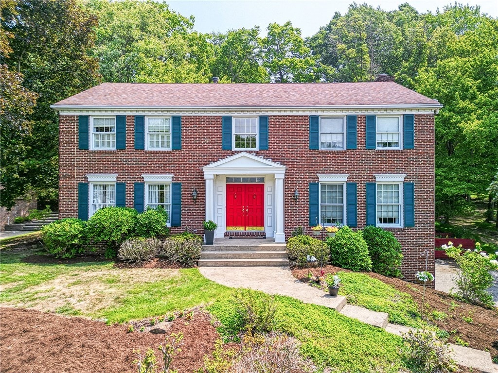 colonial home featuring a front yard