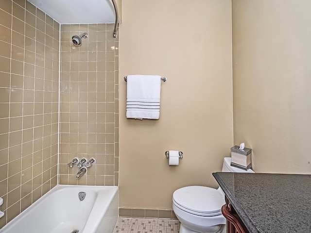 full bathroom featuring toilet, vanity, tiled shower / bath, and tile patterned floors