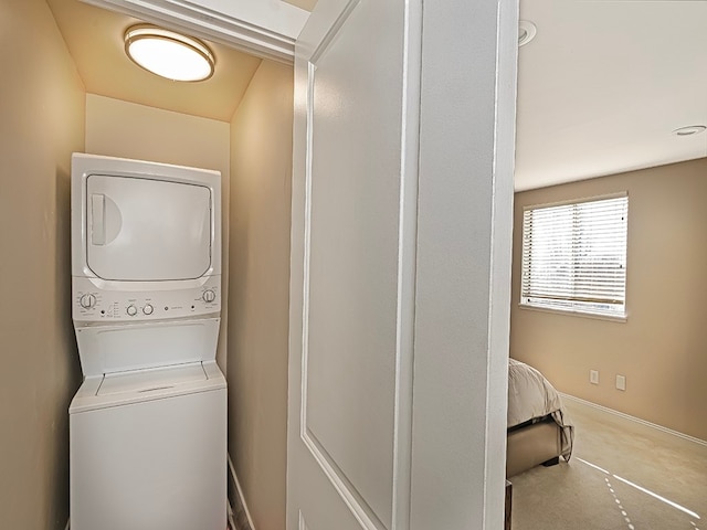 laundry area with stacked washer and clothes dryer and carpet flooring