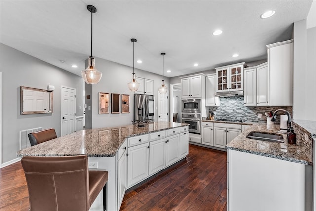 kitchen with a kitchen island, white cabinets, sink, and stainless steel appliances