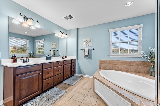 bathroom with vanity, tile patterned floors, and tiled tub