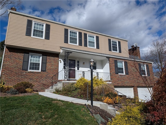 view of front of house with a garage, covered porch, and a front yard