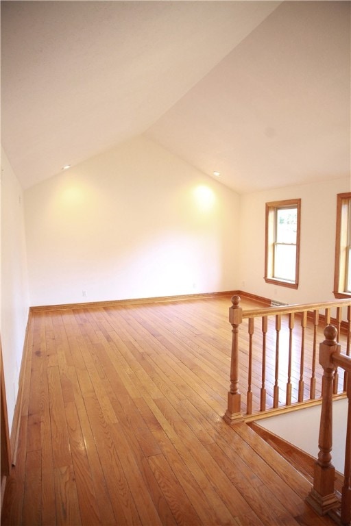 unfurnished room featuring lofted ceiling and wood-type flooring