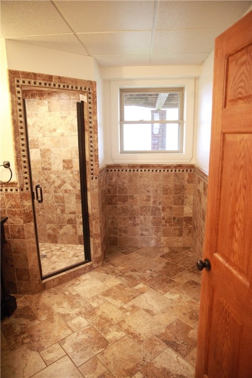 bathroom with an enclosed shower and tile walls