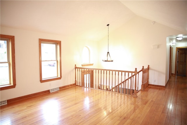 unfurnished room with lofted ceiling and hardwood / wood-style flooring