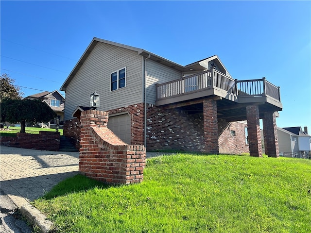 view of side of home featuring a garage, a wooden deck, and a lawn