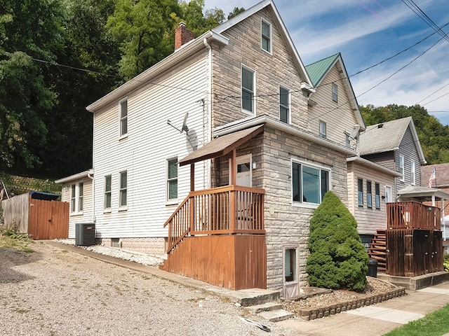 view of home's exterior with central AC, a shed, and a deck