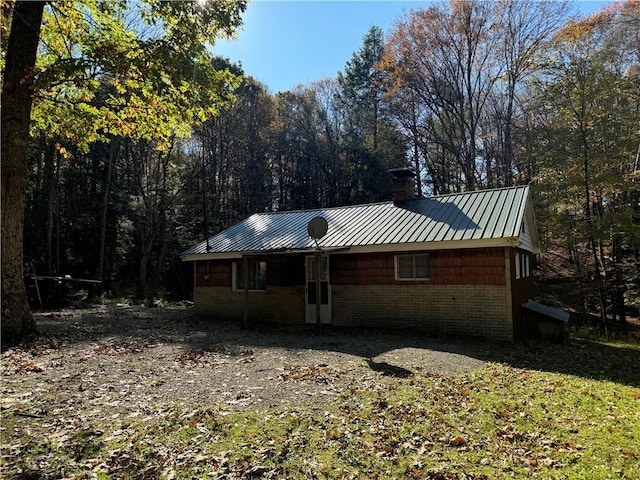 262 Shelby Ln, Northampton Township, PA 15538 - view of property exterior featuring a chimney, metal roof, and a forest view