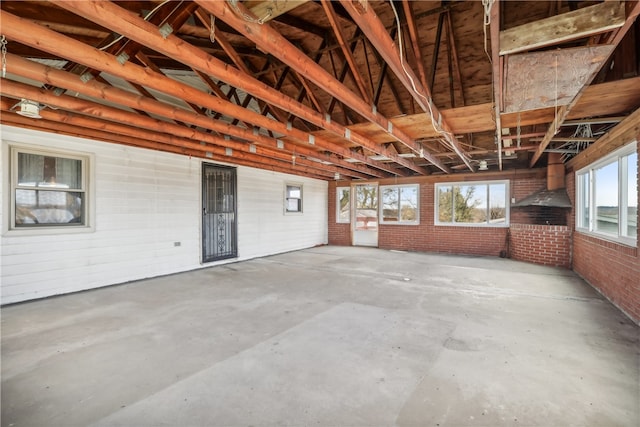 miscellaneous room featuring concrete flooring and brick wall