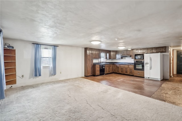 kitchen with hardwood / wood-style floors and black appliances