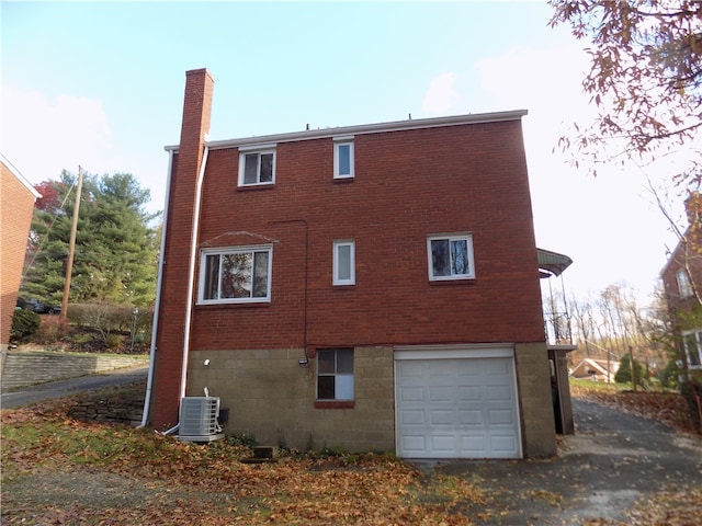 view of side of property with a garage and cooling unit