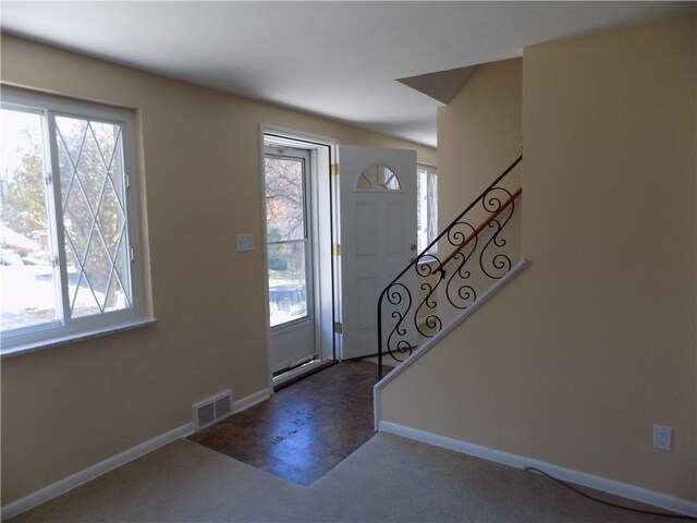 entryway with dark carpet