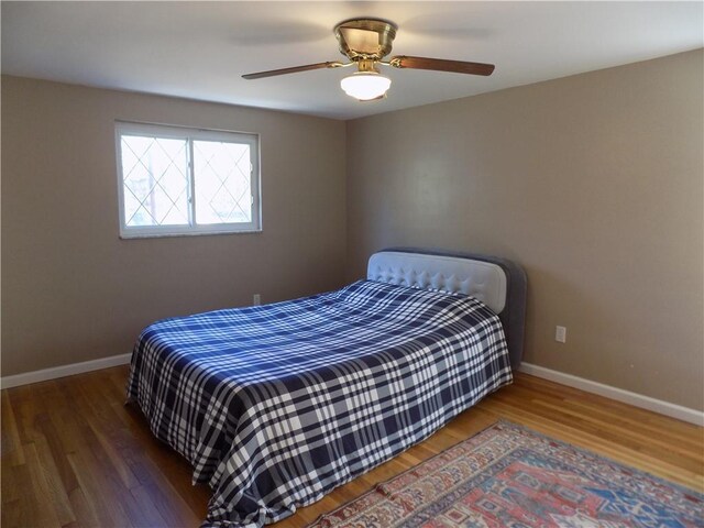 bedroom with ceiling fan and dark wood-type flooring