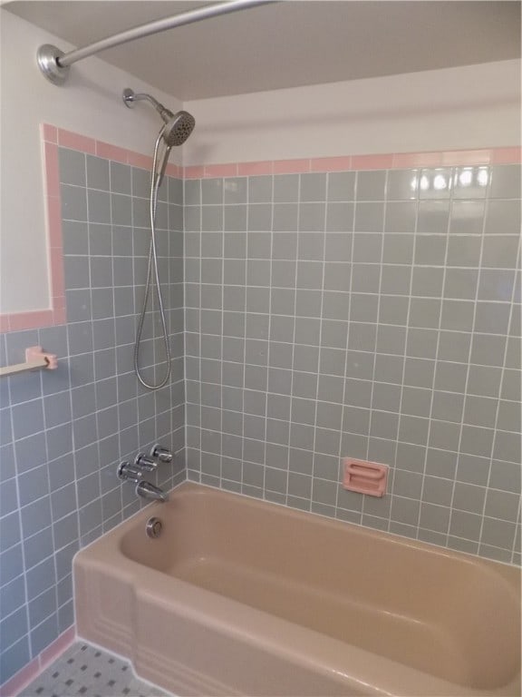 bathroom with tiled shower / bath and tile patterned floors