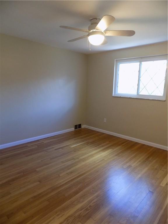 unfurnished room with ceiling fan and wood-type flooring