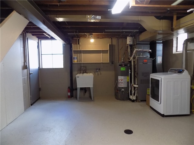 basement featuring gas water heater, washer / clothes dryer, plenty of natural light, and sink