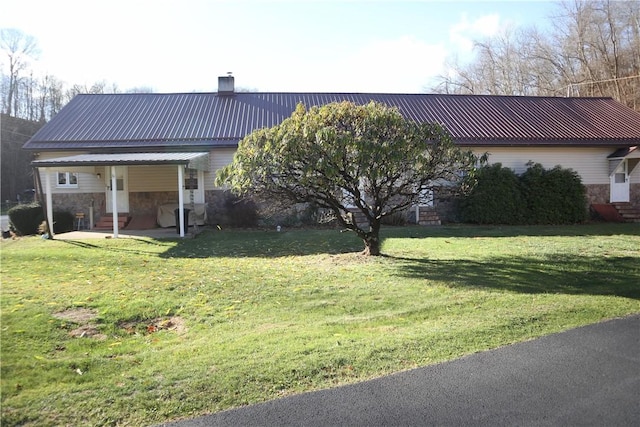 497 Pike Run Dr, W Pike Run Twp, PA 15427 - rear view of house with metal roof, stone siding, a yard, and a chimney