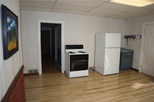 kitchen with white appliances, a paneled ceiling, and light wood-type flooring