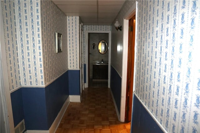 497 Pike Run Dr, W Pike Run Twp, PA 15427 - corridor featuring wallpapered walls, baseboards, a wainscoted wall, a drop ceiling, and a sink