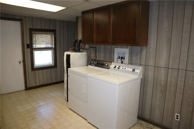 laundry room with cabinets, water heater, and washing machine and clothes dryer