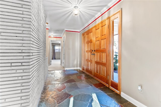 foyer with a wealth of natural light and crown molding