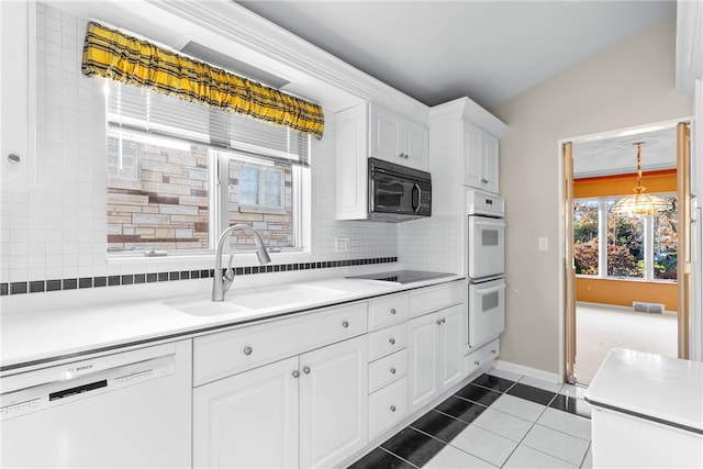 kitchen featuring black appliances, dark tile patterned floors, backsplash, sink, and white cabinets