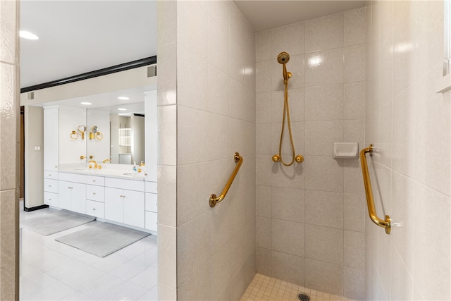 bathroom featuring tile walls, vanity, tile patterned flooring, and a tile shower