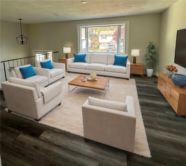 living room with dark wood-type flooring and a textured ceiling