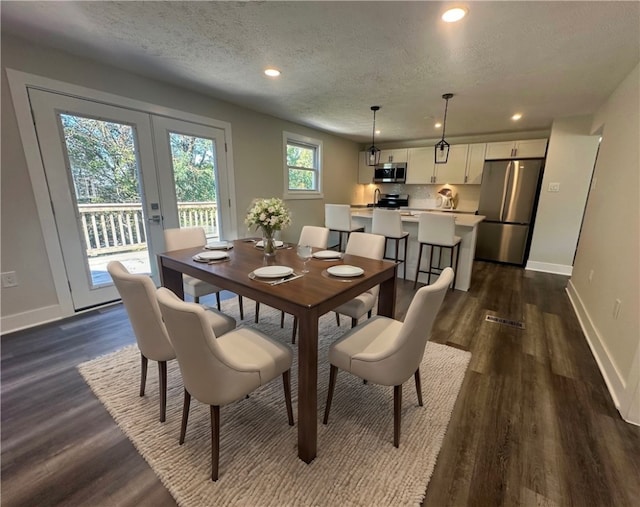 dining space with french doors, dark hardwood / wood-style flooring, and a textured ceiling