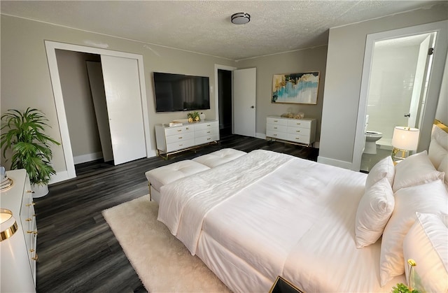 bedroom with ensuite bathroom, a textured ceiling, and dark hardwood / wood-style flooring