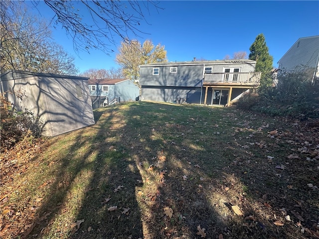 rear view of house with a wooden deck and a yard