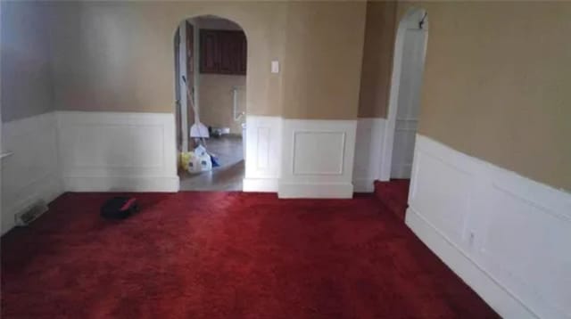 unfurnished room with dark carpet