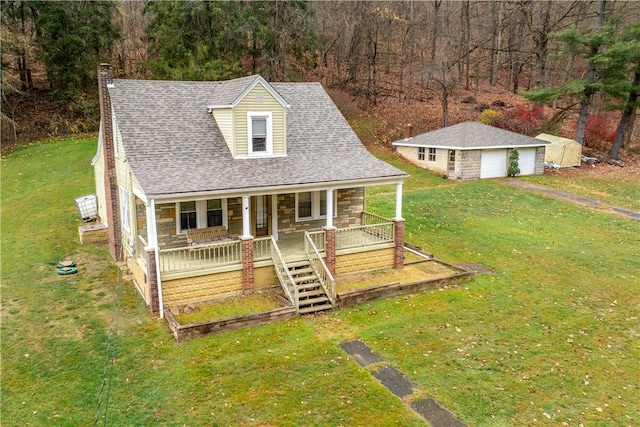 view of front facade featuring an outbuilding, a garage, a front lawn, and a porch