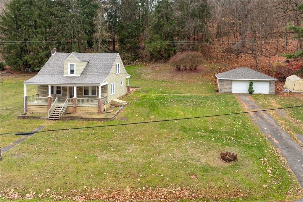 view of front of property with a front lawn, covered porch, and a storage shed