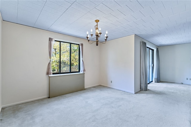 carpeted empty room featuring a notable chandelier