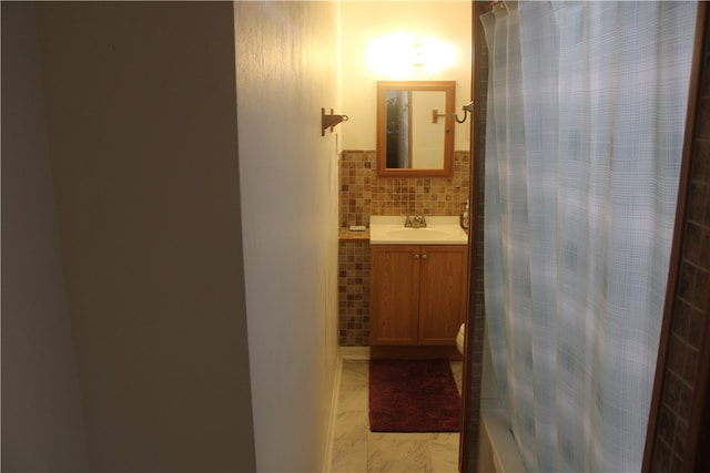 bathroom featuring vanity and tasteful backsplash