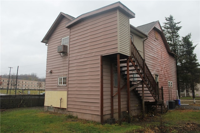 view of side of home featuring cooling unit and a yard